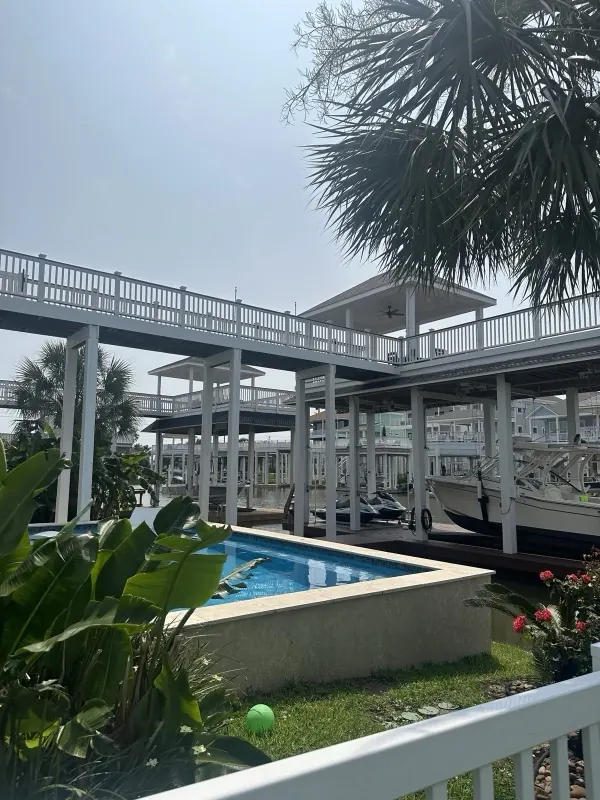 Canal-side pool and boat lifts behind the home