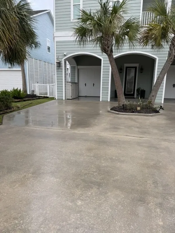 Freshly pressure-washed concrete driveway in front of a Galveston home