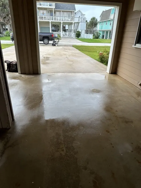 Inside a cleared garage, looking out to the driveway