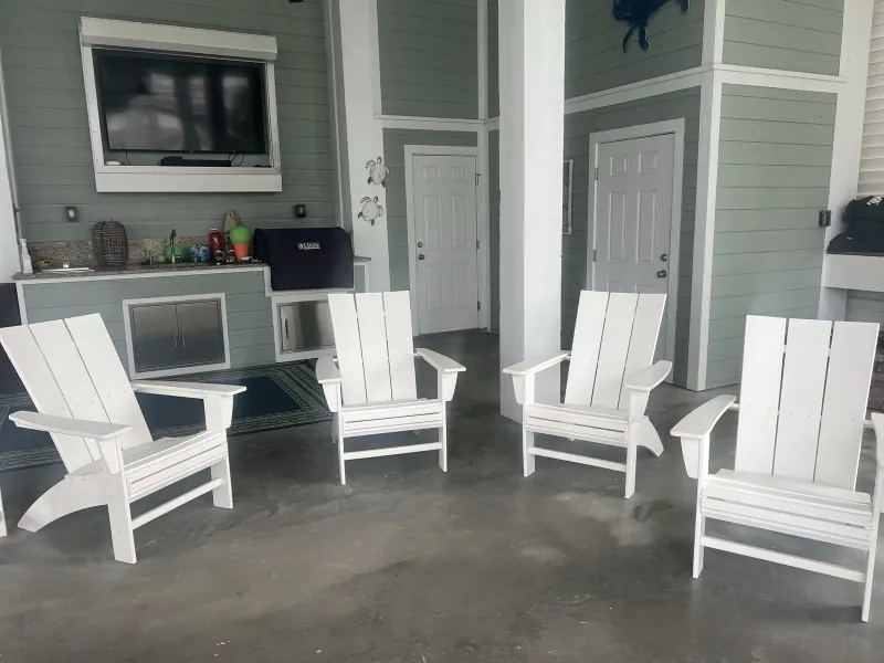 After: clean concrete floor with white Adirondack chairs