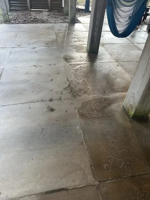 Before: concrete patio covered in construction debris and dirt