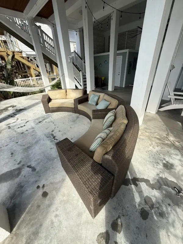 Under-house patio being washed around outdoor furniture