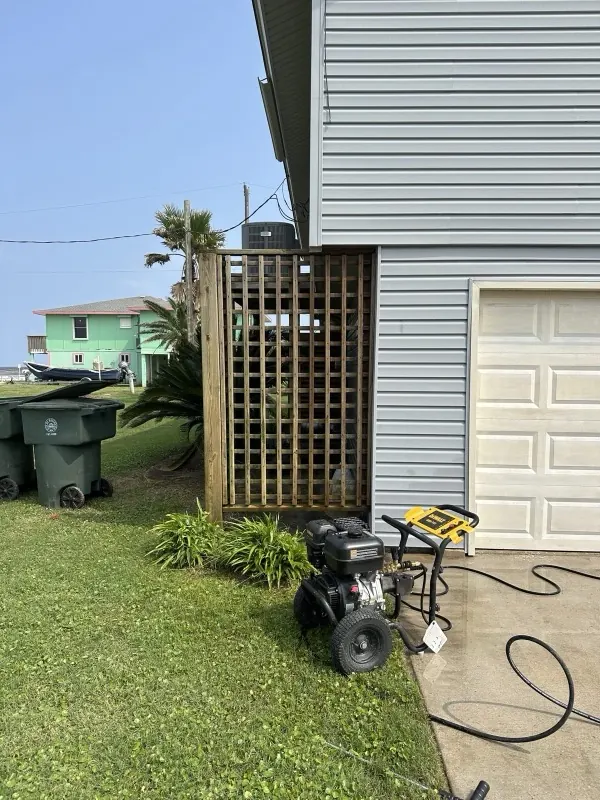 Gas pressure washer set up beside a garage on a job