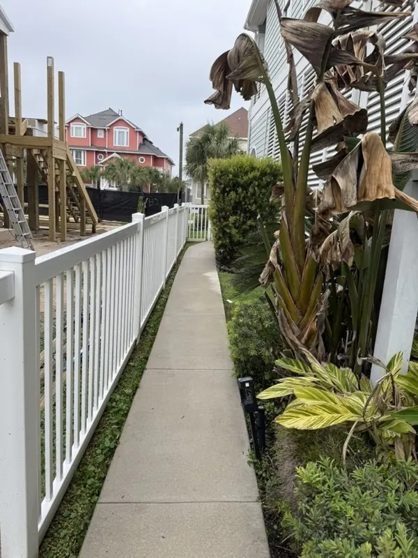 Clean side walkway along a white fence