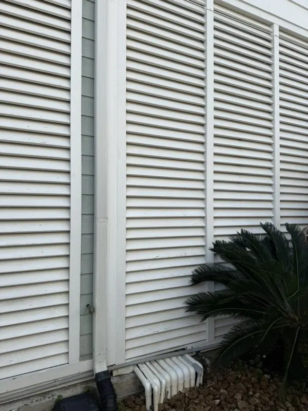 Washed white storm shutters and downspout